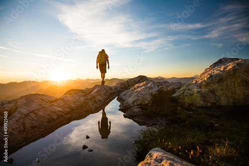 reflected view of backpacker hiking on mountain rige. photo