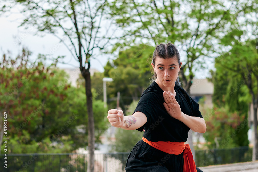 Woman in uniform praticing martial arts in a park Woman in uniform praticing martial arts in a park