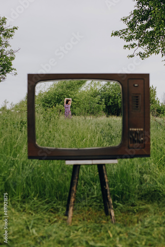 Girl in old television frame box outdoors photo