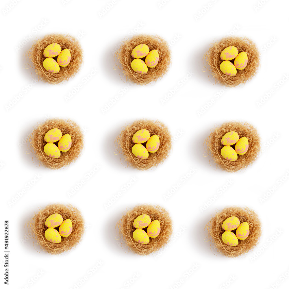 Pattern yellow pastel easter eggs in nests on a white background. Minimal creative concept of Easter. Pattern yellow pastel easter eggs in nests on a white background. Minimal creative concept of Easter.