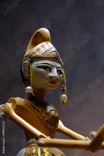 detail of an oriental statuette with golden hat
