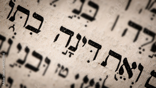 Obraz na płótnie Hebrew word in Torah page. English translation is name Dinah. Daughter of Jacob and Leah. Selective focus. Closeup. w salonie