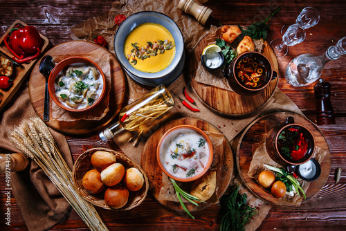 A table on which there are traditional Ukrainian dishes. Dumplings, pumpkin soup and solyanka. Top view © Alexey Tsibin