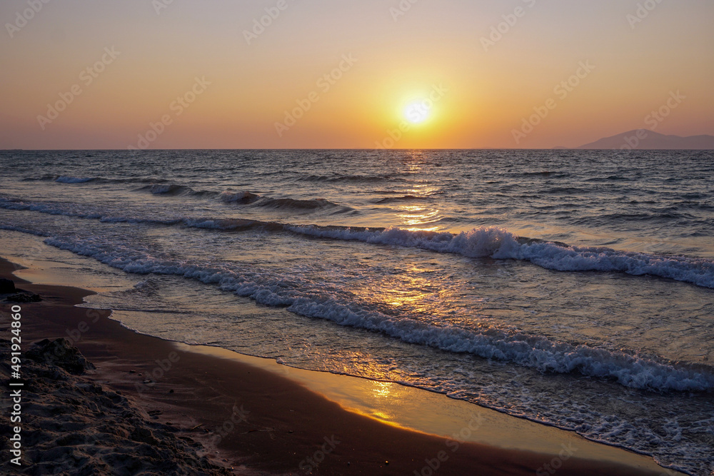 Obraz premium A sunset over the sea with waves