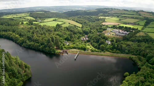 Water catchment reservoir with concrete dam revealing distant rainy views