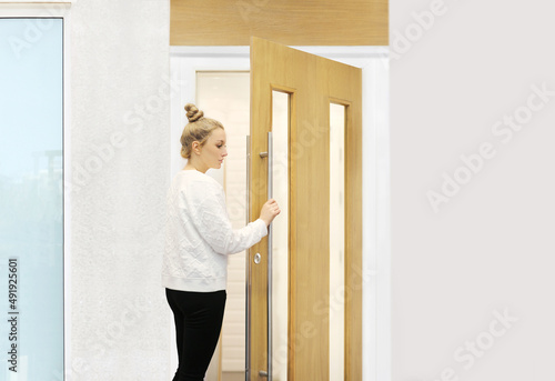 Beautiful woman opening the door of her home.