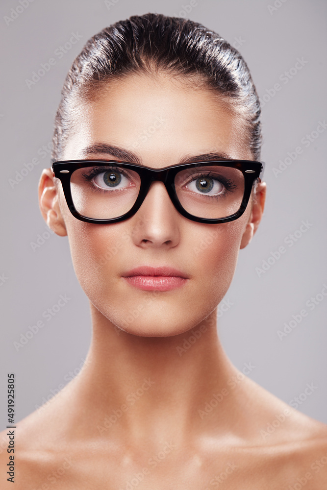 Smart and beautiful. Studio portrait of a beautiful young woman wearing glasses against a gray background. Smart and beautiful. Studio portrait of a beautiful young woman wearing glasses against a gray background.
