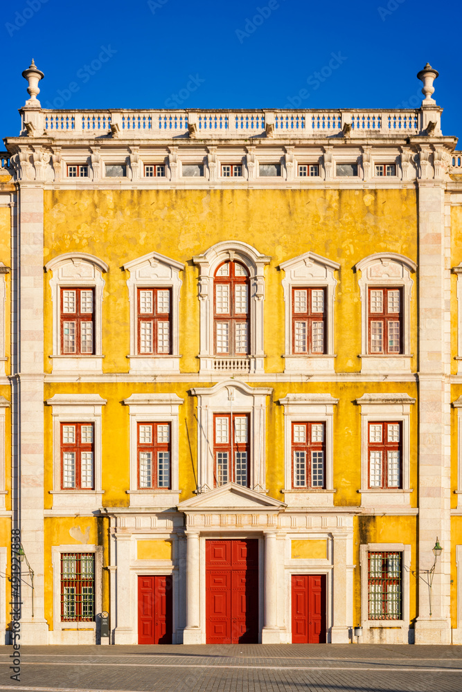 Mafra Palace facade with red doors and windows, in Portugal