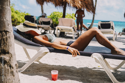 Mujer posando en bikini con un cóctel en una playa tropical
 photo