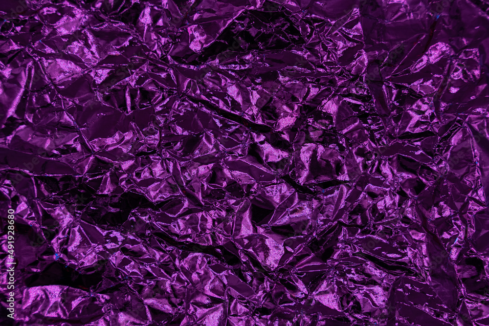 Crumpled very peri or violet foil background. Abstract pattern. Trendy color of the Year 2022.