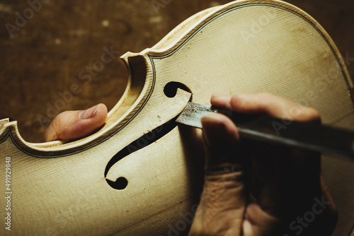 Unrecognized luthier creating a violin and using tools photo