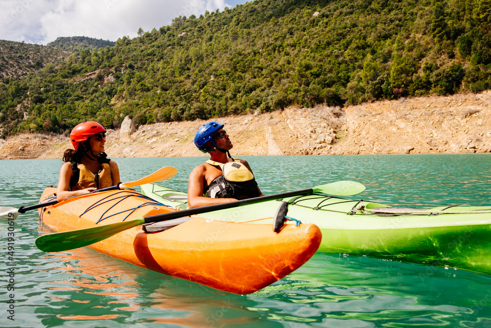 © Cavan Images - Front view of couple sailing on a mountain lake.