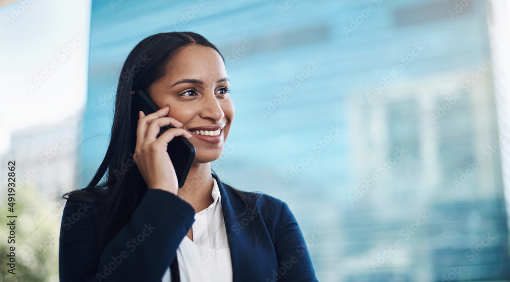 Successful people match their words with their actions. Shot of a young businesswoman using a smartphone against a city background. Successful people match their words with their actions. Shot of a young businesswoman using a smartphone against a city background.