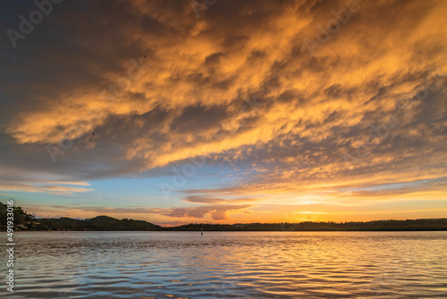 Sunrise by the bay with cumulonimbus clouds