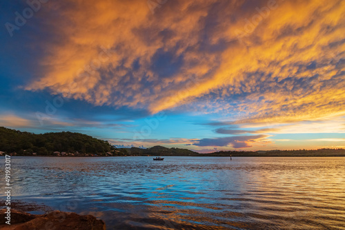 Sunrise by the bay with cumulonimbus clouds