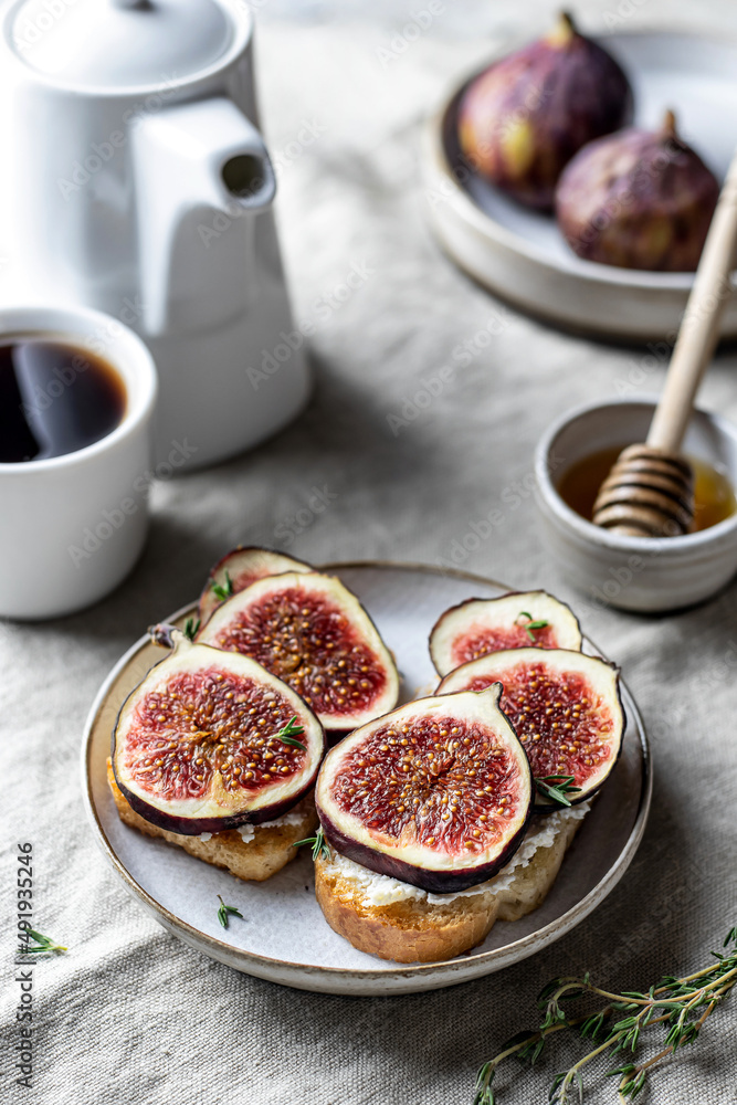 Two sandwiches with figs, thyme on textured background. Breakfast composition Two sandwiches with figs, thyme on textured background. Breakfast composition
