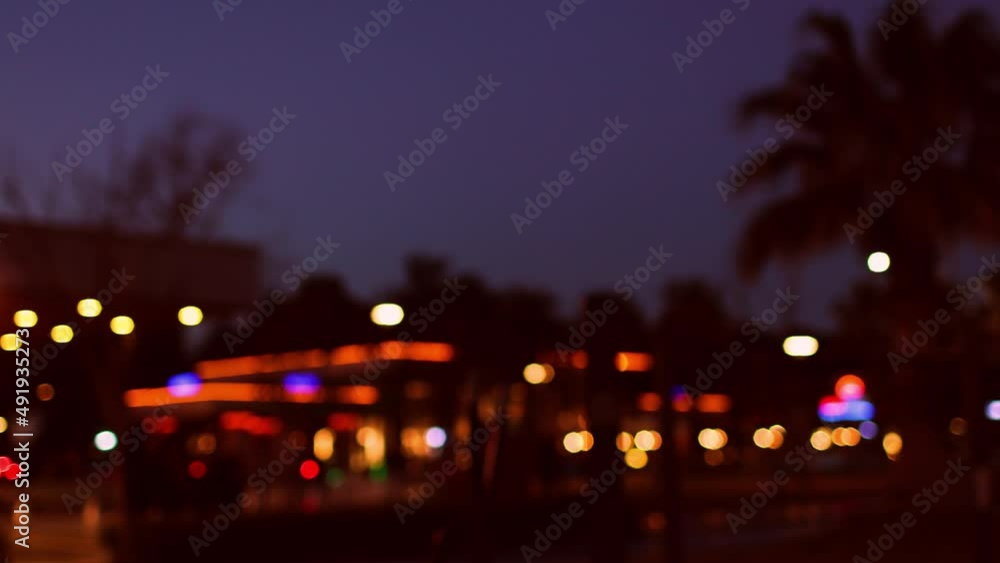 resort town at sunset blurred background, palm trees against the sunset sky, embankment street, cars and people on the city street resort town at sunset blurred background, palm trees against the sunset sky, embankment street, cars and people on the city street