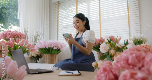 SME owner modern small flower shop work at home office happy smile fist up read text e-mail message banking lending money online. Young adult woman asia people joy seller job in sale order good news. photo