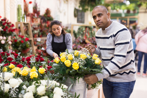 Male customer chooses flowers in flower shop © JackF