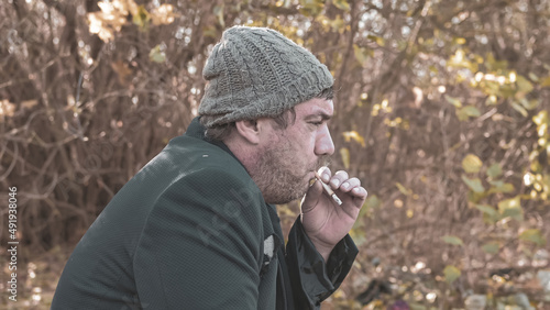 Quadro su tela a poor homeless man with dirty hands smokes a cigarette in modern society