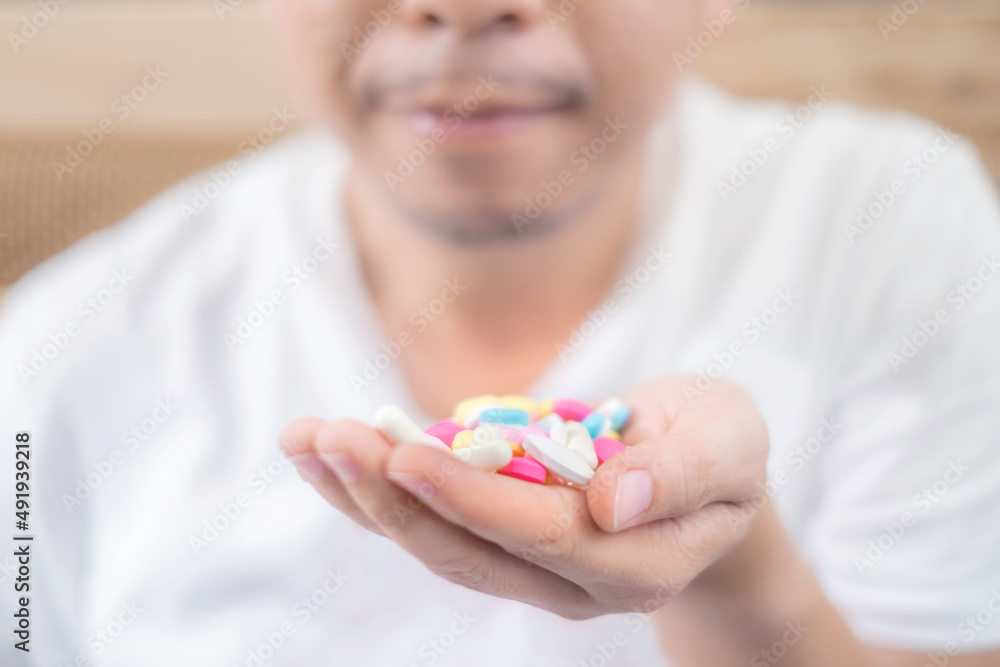 Close up of the man hand with pills committing suicide by overdosing on medication Close up of the man hand with pills committing suicide by overdosing on medication