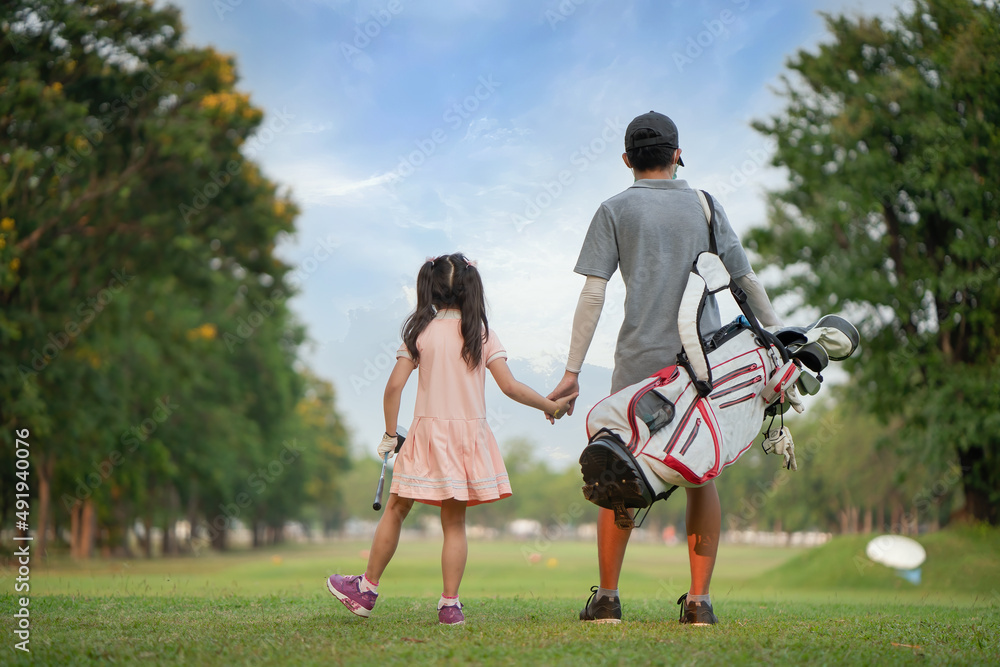 Obraz premium Brother takes his sister's hand to play golf.