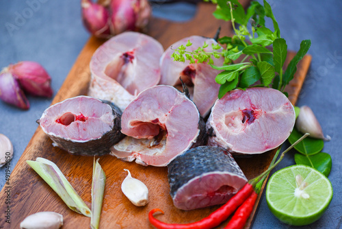 Fresh raw Snake head fish menu freshwater fish, Snakehead fish for cooking food, striped snakehead fish chopped with ingredients herb and spices on wooden cutting board and table kitchen background