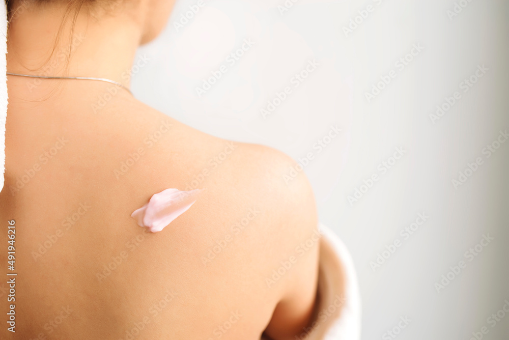 Woman back with cream lotion. Skin care concept. Close up