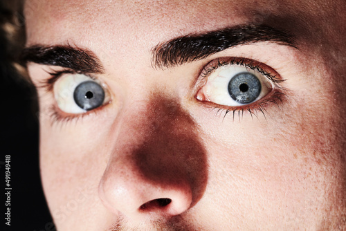 He saw a ghost. Closeup portrait of a young man with wide eyes and small pupils. photo
