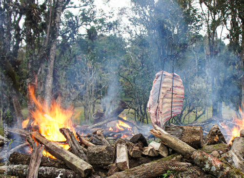 Cstela de chão, churrasco típico do sul do Brasil, carne sendo assada em espeto na fogueira photo