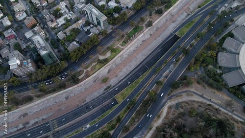 Aerial top down dolly in of Mapocho river and cars driving in avenues and highway and Santiago city neighborhood buildings, Chile photo