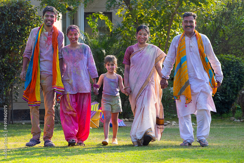 Indian family celebrating Holi together in the garden Indian family celebrating Holi together in the garden