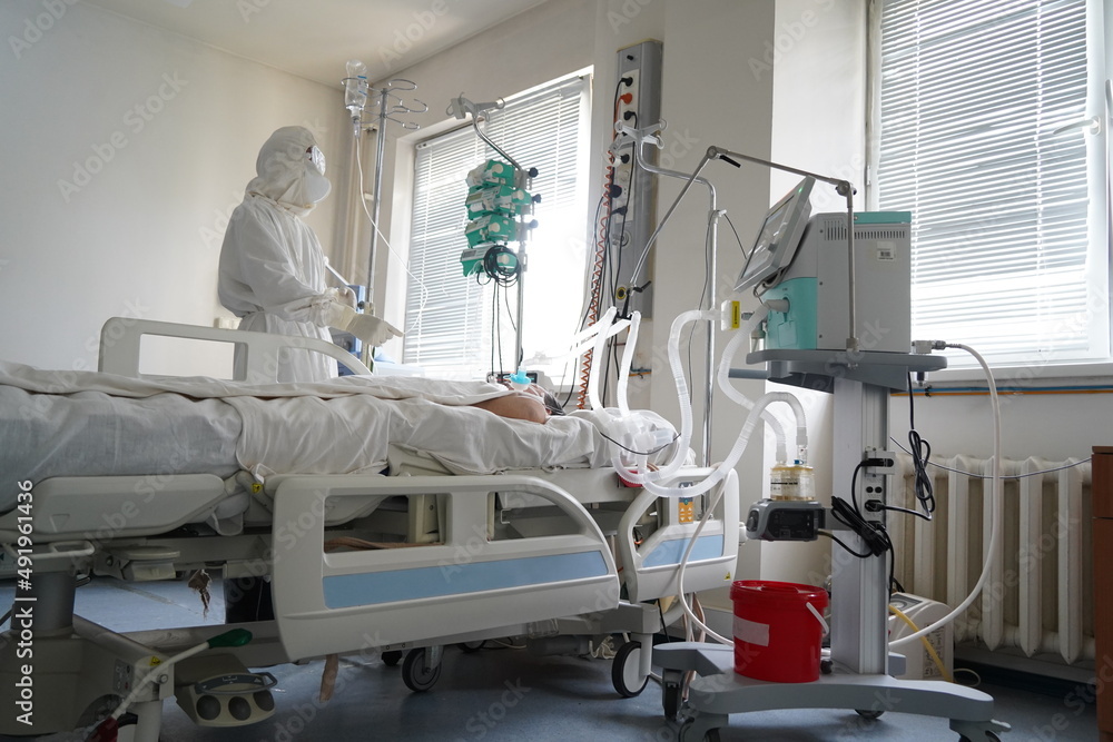 Almaty, Kazakhstan - 06.18.2021 : The doctor regulates the IV for a patient with covid 19 Almaty, Kazakhstan - 06.18.2021 : The doctor regulates the IV for a patient with covid 19