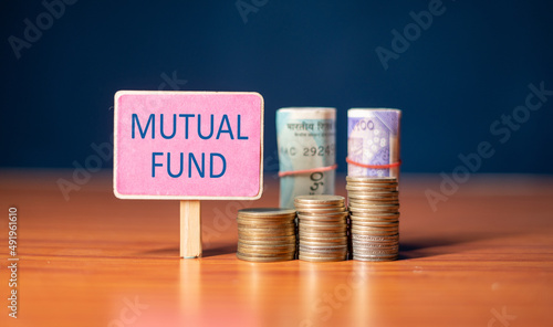 mutual fund sign board with growing coins and stack of money - concept of Investment, savings and wealth creation. photo