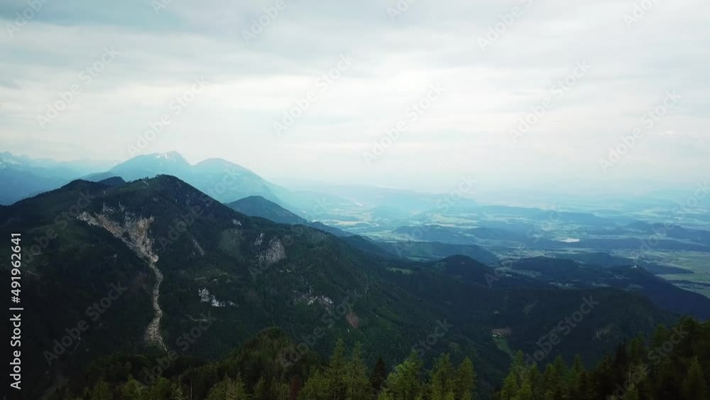 A aerial view from Hochpetzen in the Karawanks in Carinthia, Austria. Panoramic view on the valley and the surrounding mountains. Overcast. Border with Slovenia. Landscape recording.Aerial photography A aerial view from Hochpetzen in the Karawanks in Carinthia, Austria. Panoramic view on the valley and the surrounding mountains. Overcast. Border with Slovenia. Landscape recording.Aerial photography