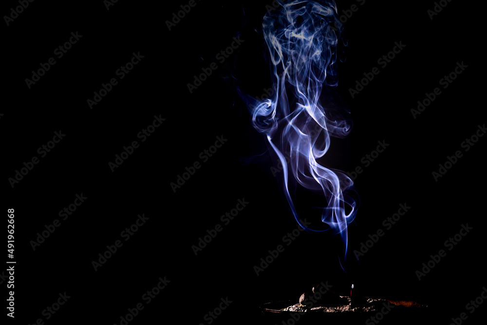 Closeup of smoke from burning incense stick on black background Closeup of smoke from burning incense stick on black background