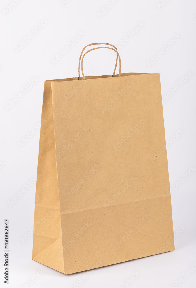 paper shopping bag. Kraft bag. It stands on a white background. Taken in detail from close-up. paper shopping bag. Kraft bag. It stands on a white background. Taken in detail from close-up.
