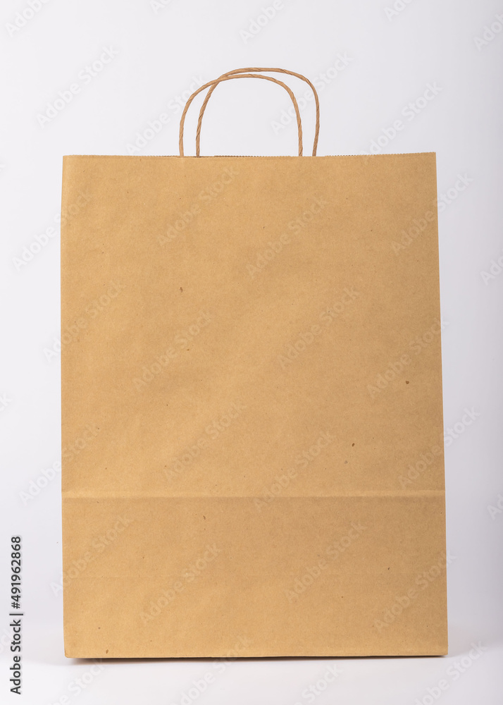 paper shopping bag. Kraft bag. It stands on a white background. Taken in detail from close-up. paper shopping bag. Kraft bag. It stands on a white background. Taken in detail from close-up.