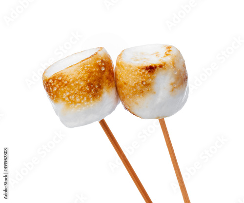 Grilled marshmallows on sticks isolated on white