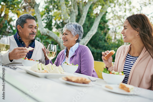 Dads jokes have them rolling in the aisles. Cropped shot of a family enjoying lunch and wine together outside.