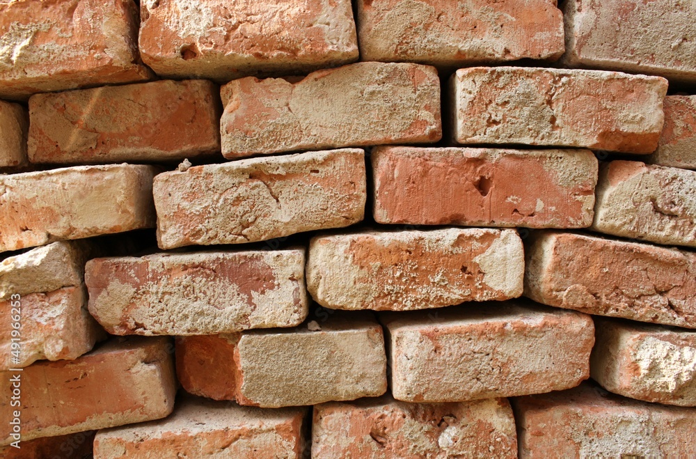 an irregular stone wall made of old red bricks an irregular stone wall made of old red bricks