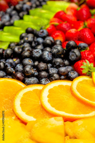Fototapeta Naklejka Na Ścianę i Meble -  Fresh fruits concept, Arrangement of orange kiwi and assorted berry as background