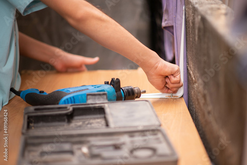 Boy teenager use screwdriver fix wood table