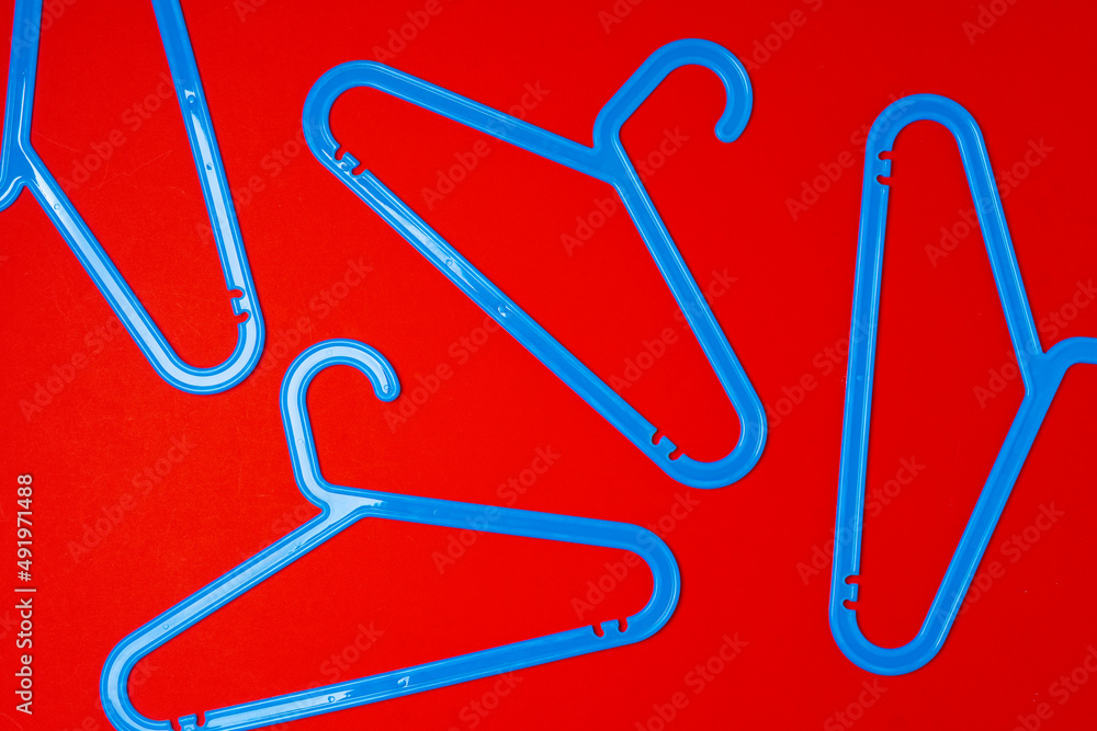 Hanger on red paper background. Minimalistic fashion concept. Top view Hanger on red paper background. Minimalistic fashion concept. Top view
