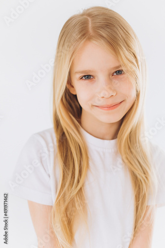 Young blondie girl portrait. Natural blondie hair, happy smiling caucasian girl on white background