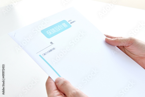 手に持たれた保険設計書
