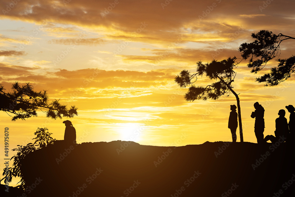 silhouette people on mountain with sunset background