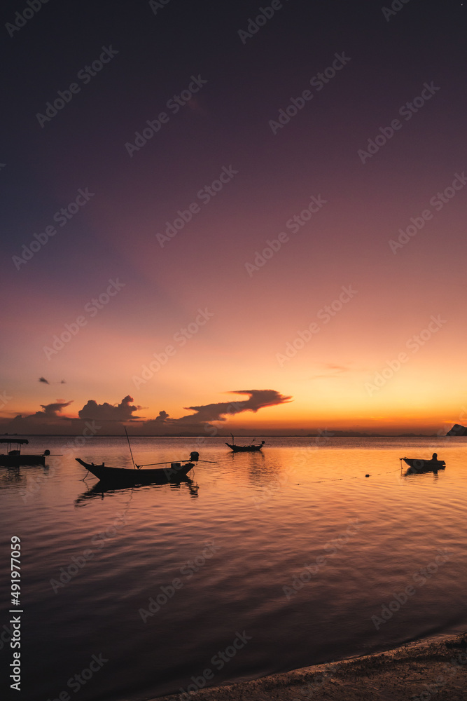 Silhouettes of fishing boats on the sea at a beautiful sunset