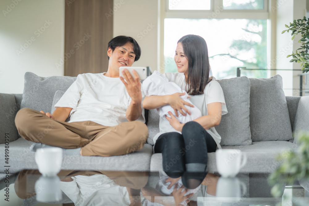 部屋でスマホを使う赤ちゃんを抱く男女
部屋でスマホを使う赤ちゃんを抱く男女