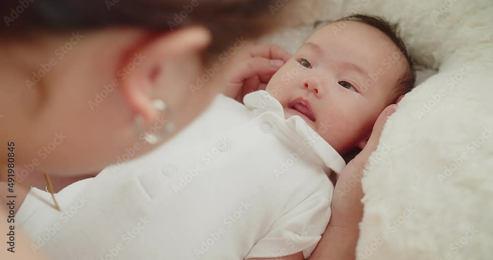 happiness family mother playing kissing adorable newborn baby infant child girl lying on bed at home, baby looking at her mom face and smile, children, parenthood, childhood, motherhood love concept happiness family mother playing kissing adorable newborn baby infant child girl lying on bed at home, baby looking at her mom face and smile, children, parenthood, childhood, motherhood love concept